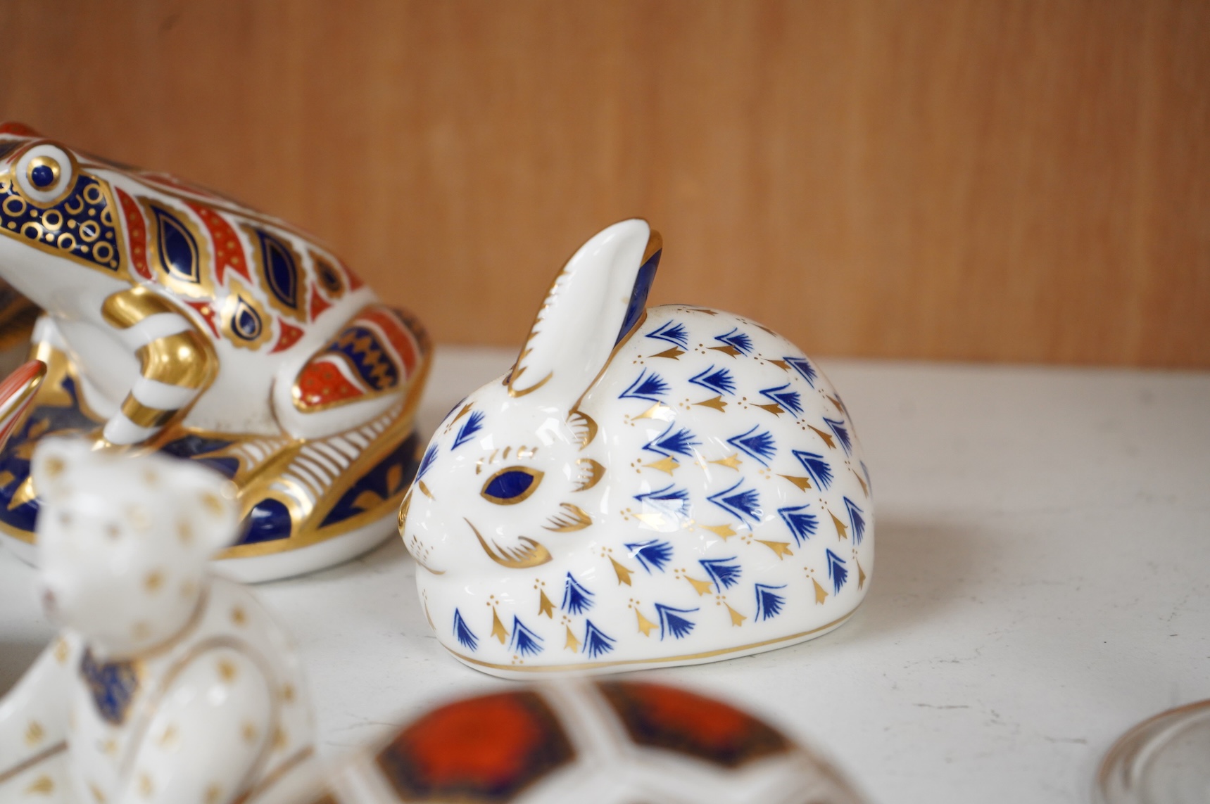 A collection of Royal Crown Derby Imari pattern paperweights, to include penguin and badger, together with three Doulton flambé animals, largest 19cm wide